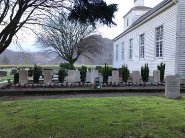 A cemetery with a church in the background  Description automatically generated with low confidence